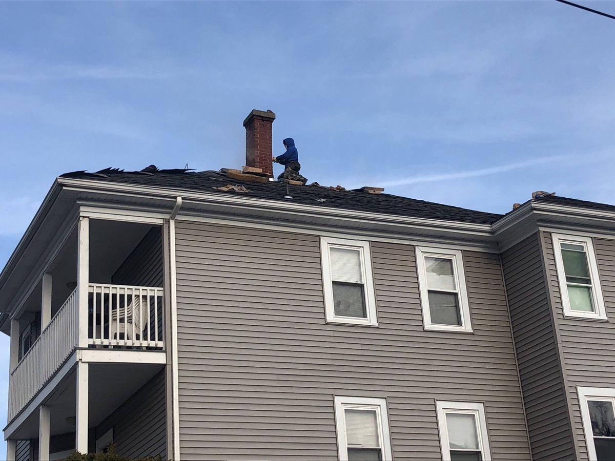 Chimney repointing during Lincoln RI roof replacement