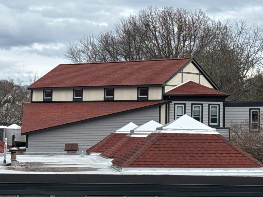 East Providence RI commercial building roof replacement with red shingles and pyramid skylights.