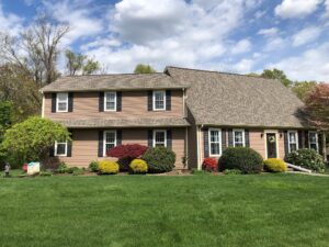 Residential roof replacement in Lincoln, RI, with new asphalt shingles and matching gutters.