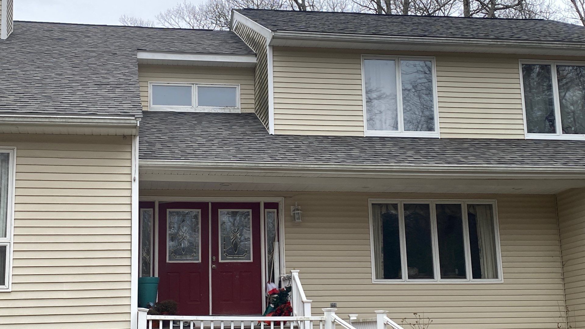 Front entry view with new roof and red double doors, Cumberland residential roofing