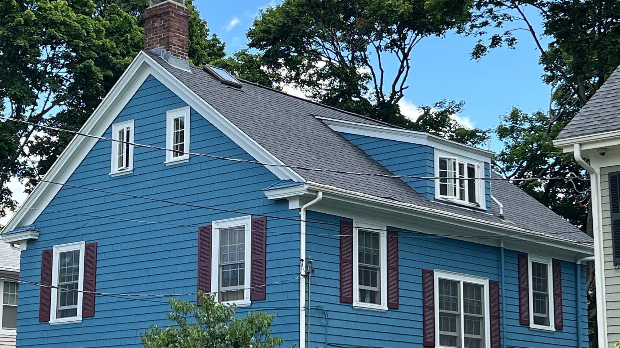 Angled view of new roof over blue colonial, Providence roof repair