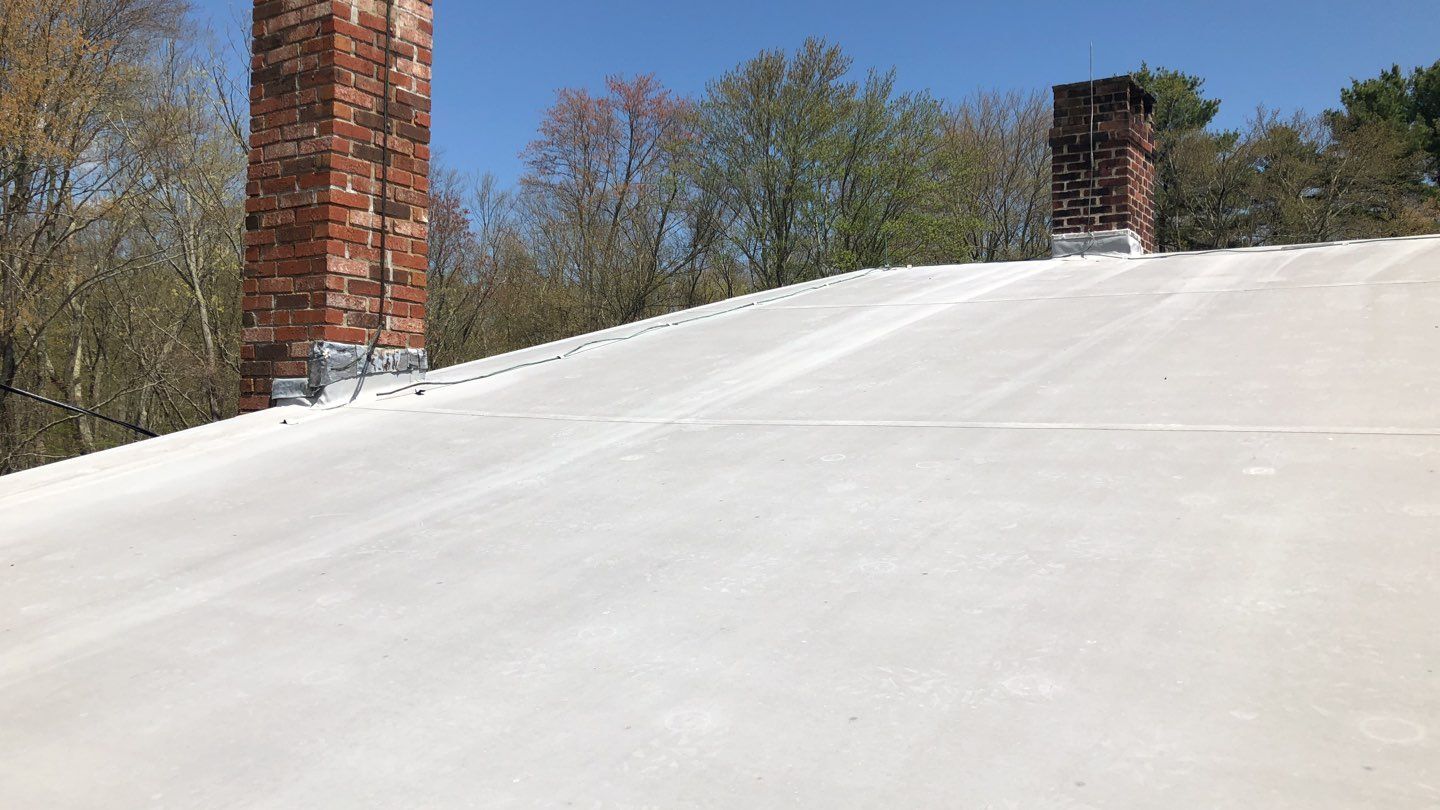 After — Foster, RI Commercial Flat-Roof Replacement — New Membrane on a Working Farm Building