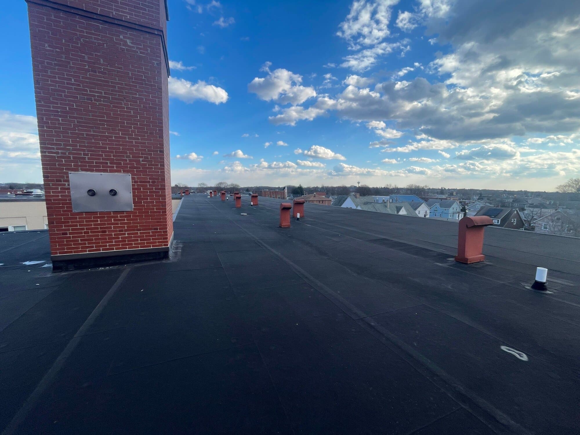 After — East Providence, RI Commercial Roofing: Low-Slope Flat Roof System on a Large Brick Building