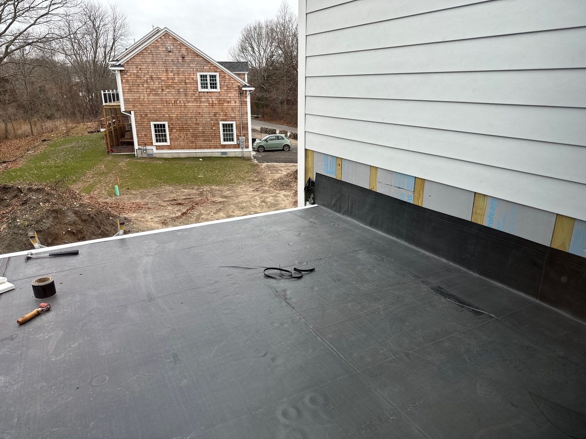 Roof-to-siding transition detail showing integrated flashing between Landmark Premium shingles and Hardie Panel