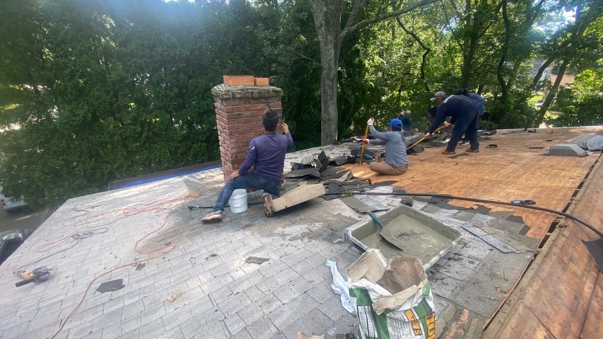 Roofer rebuilding chimney flashing North Kingstown RI roof repair