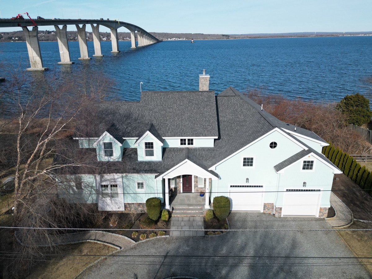 Waterfront home before exterior renovation with James Hardie siding and new roof in Jamestown RI