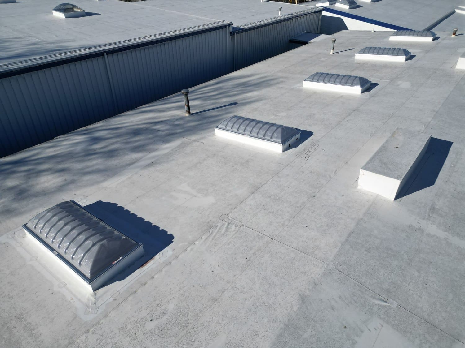 Dome skylights across the white commercial roof in Warren