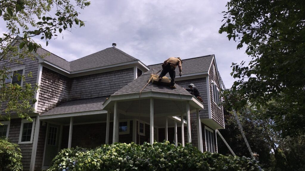 Roofers repair asphalt shingles on a home in Ashaway, RI, ensuring long-lasting protection.